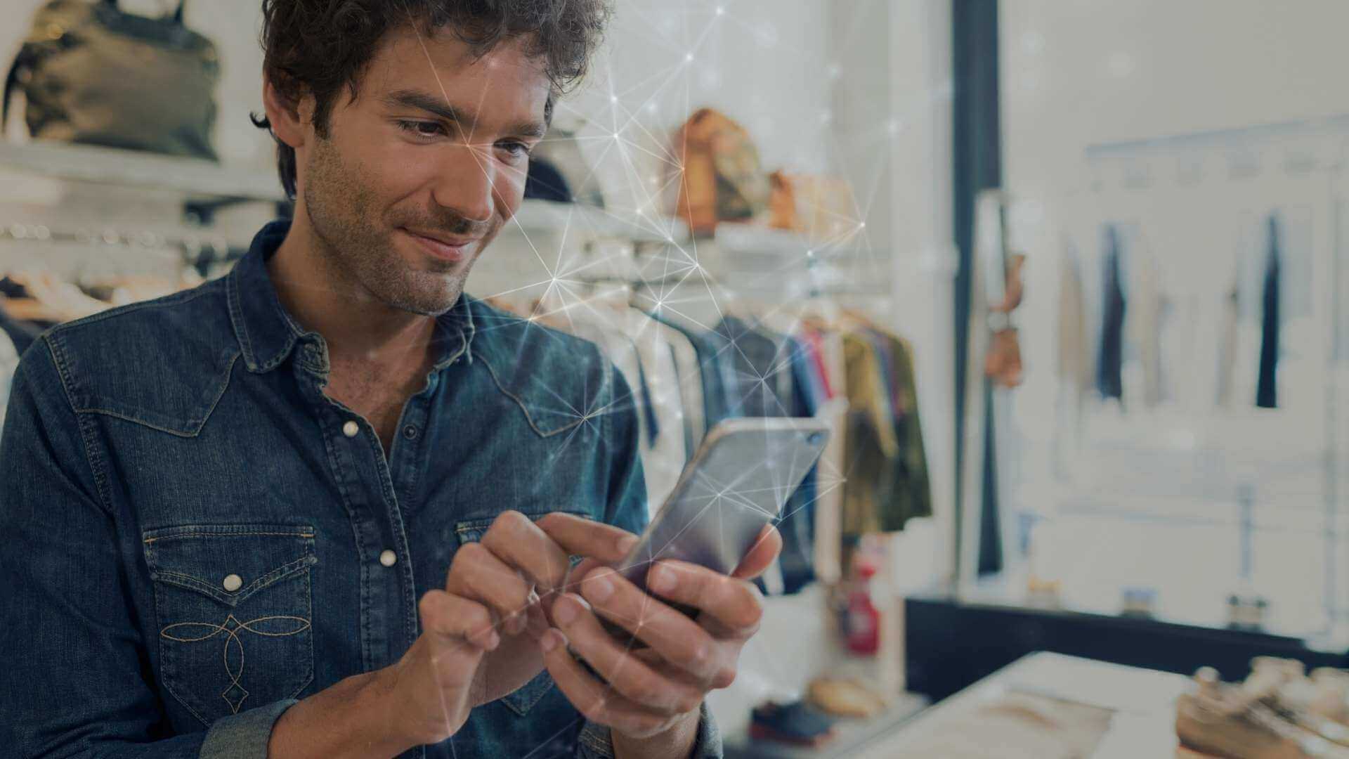 men looking at his phone inside a fashion store