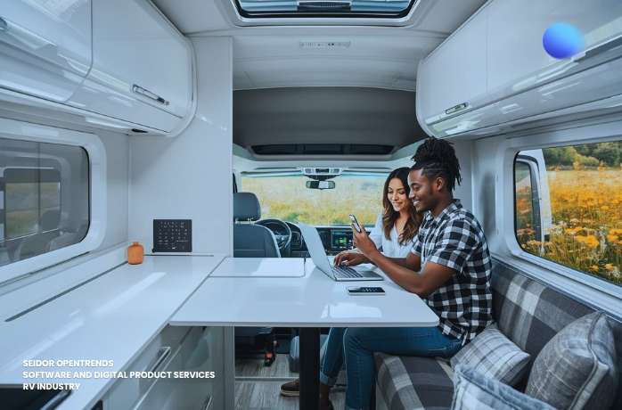 couple inside an RV trailer working on laptop with internet conenction