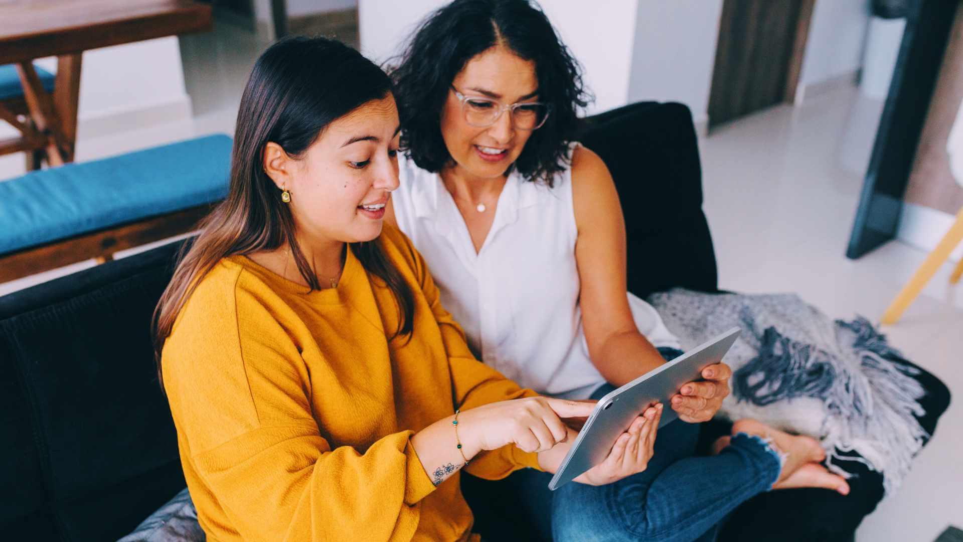 Mother and Daughter Watching Something on Tablet at Home