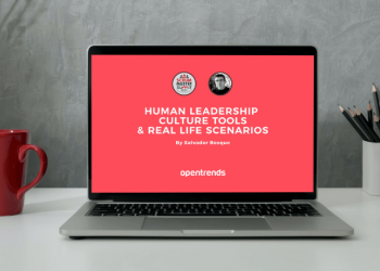 open laptop on top of a table next to a red coffee mug