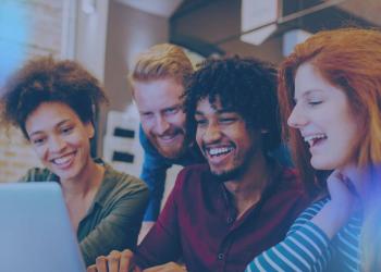 happy young individuals in front of a computer