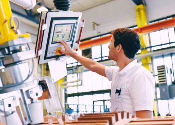 young mechanical engineering workers operate a machine for winding copper wire