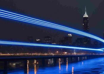 A blue neon curvy lines beaming against the city lights