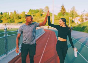 2 Athletic individuals Doing High Five Outdoors