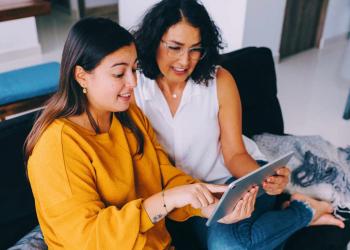 Mother and Daughter Watching Something on Tablet at Home