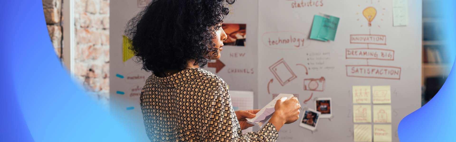 a woman in front of a white board conducting user workshop