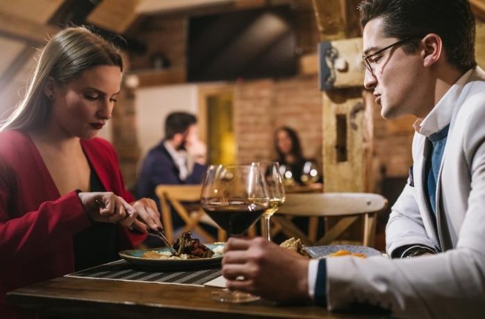woman and man sitting at a table having diner