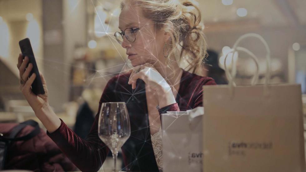 woman looking at her phone at a restaurant table