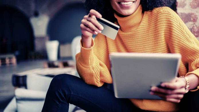 woman holding tablet and credit card