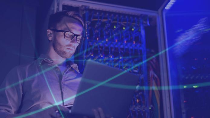 IT engineer at work surrounded by data centers